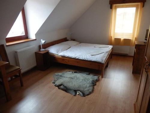 ein Schlafzimmer mit einem Bett und einem Teppich auf dem Boden in der Unterkunft Penzion Dočkalův mlýn in Havlíčkův Brod