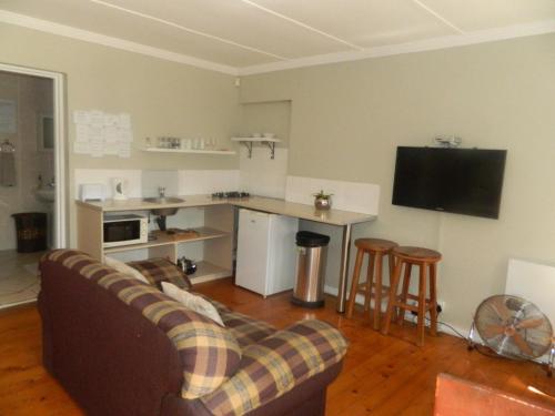 a living room with a couch and a kitchen at 4 Elements lodge in Queenstown
