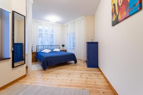 um quarto com uma cama azul num quarto em Victus Apartamenty, Apartament Etna em Sopot