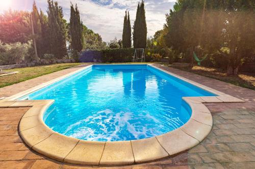 una piscina en un patio con un patio de piedra en Appartamento Villa Matone, en Grottaferrata