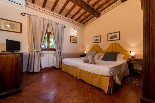 a bedroom with a bed and a television in it at Agriturismo Parco Fiorito in Cortona