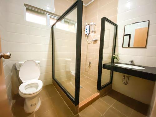 uma casa de banho com um WC, um chuveiro e um lavatório. em Metro Pines Inn em Baguio