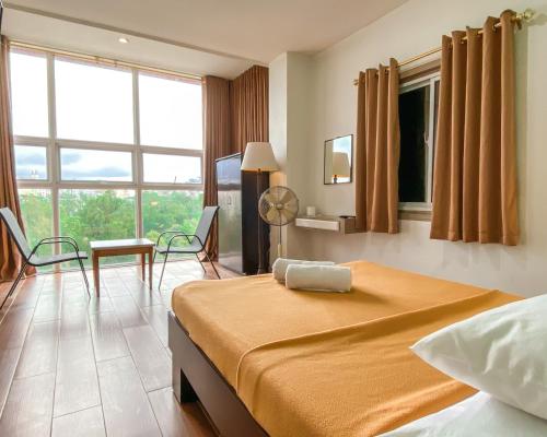 um quarto de hotel com uma cama e uma grande janela em Metro Pines Inn em Baguio