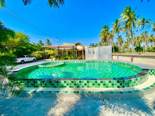 a swimming pool in a resort with a car parked in the background at ศรีสุภาวดีรีสอร์ท-Srisupawadee resort in Prachuap Khiri Khan