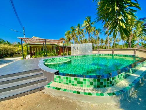 ศรีสุภาวดีรีสอร์ท-Srisupawadee resort في براشاوب خيرى خان: مسبح وبلاط اخضر في منتجع