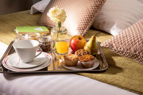 a tray of food on a table with a cup of coffee at Hotel Relais Bosquet by Malone in Paris