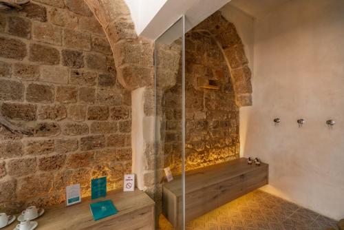 a bathroom with a shower in a brick wall at Akotika boutique in ‘Akko