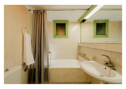 y baño con bañera, lavamanos y bañera. en Elounda Collection Apartments, en Elounda