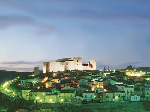 a castle on top of a town at night at Il Castagneto Hotel in Melfi