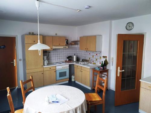 eine Küche mit einem Tisch, einem Tisch und Stühlen in der Unterkunft Gästehaus Maurer in Gau-Weinheim