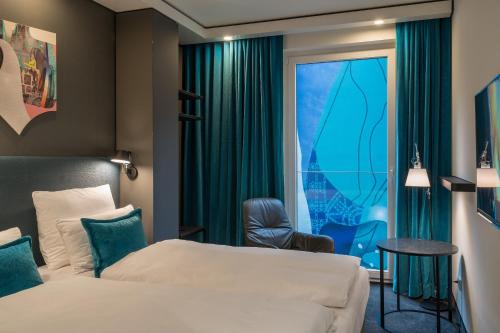 um quarto de hotel com uma cama e uma janela em Motel One Berlin-Alexanderplatz em Berlim