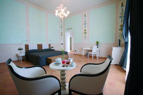 a living room with a bed and a table and chairs at Miglio d'Oro Park Hotel in Ercolano