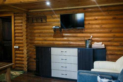a living room with a tv on a wooden wall at Котедж-парк Славна in Okhtyrka