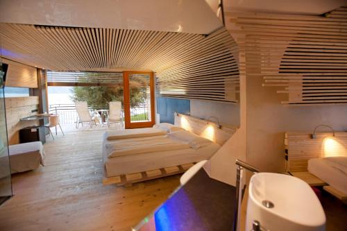 a large room with two beds and a balcony at Ambienthotel PrimaLuna 3S in Malcesine