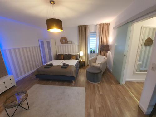 a bedroom with a bed and a couch and a chair at Pension Reinhardshäusle in Reinhardshausen