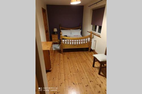 a bedroom with a bed and a wooden floor at Townhouse 3 Barrow Lane in Bagenalstown