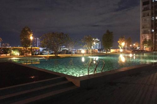 a large swimming pool at night with lights at B17-15-Amazing Lake view studio unit, Hyve,Cyberjaya, Free WiFi, Free Parking, Netflix, Pool, 3044 in Cyberjaya