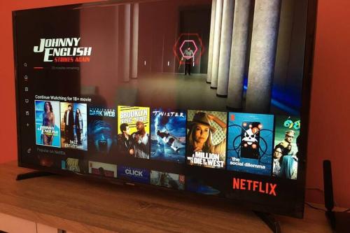 a flat screen tv sitting on a table with movies at B17-15-Amazing Lake view studio unit, Hyve,Cyberjaya, Free WiFi, Free Parking, Netflix, Pool, 3044 in Cyberjaya