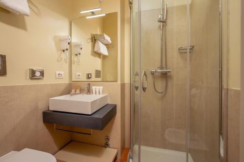 
a bathroom with a shower, toilet, and sink at Hotel Mozart in Rome
