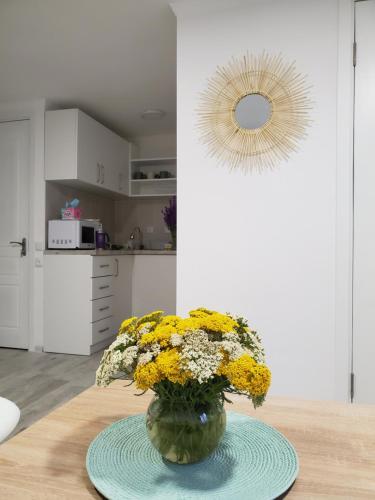 a vase with yellow flowers on a table in a kitchen at Central Guesthouse Gyumri in Gyumri