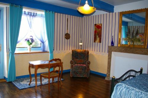 a bedroom with a bed and a table and a chair at Gîte Chez Jo in Longchamp-sur-Aujon