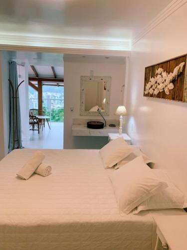 a bedroom with a large bed and a mirror at Hotel Pousada 7 Mares in Itapema