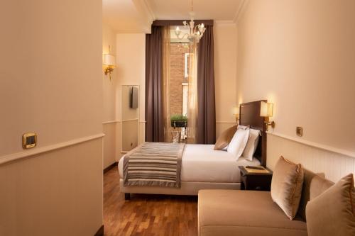 une chambre d'hôtel avec un lit et un canapé dans l'établissement Hotel Del Corso, à Rome