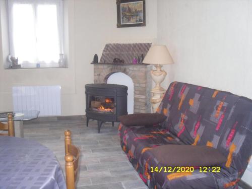 uma sala de estar com um sofá e uma lareira em Maison - Chambre d’hôte située au cœur d Asfeld em Asfeld
