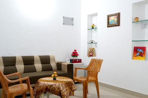 a living room with a couch and two chairs at Pearl Inn in Kottakkal