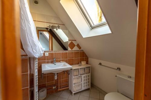 a bathroom with a sink and a skylight at Le Colombier de Hanches - Teritoria in Hanches