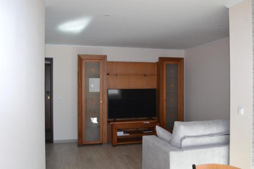 a living room with a couch and a flat screen tv at Rocha Apartment 1016 in Portimão