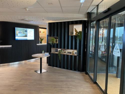 a meeting room with a table and a wall of windows at Hôtel Akena Troyes - La Chapelle St-Luc in Troyes