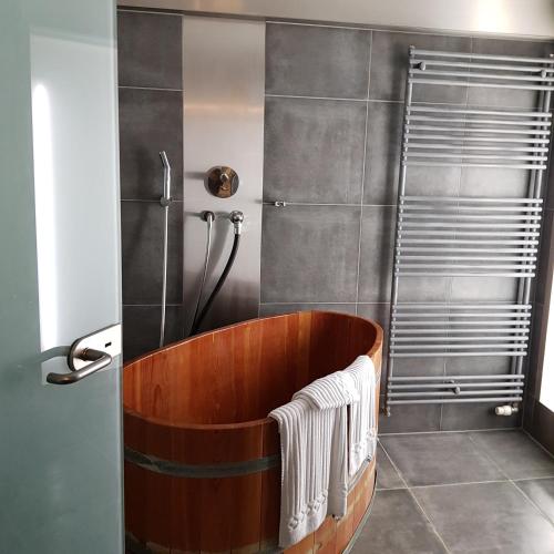 uma banheira de madeira na casa de banho com um chuveiro em Gasthof zum Lamm em Mühlheim an der Donau