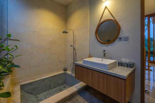 a bathroom with a sink and a tub and a mirror at Lavanya Ubud Romantic Villas in Ubud