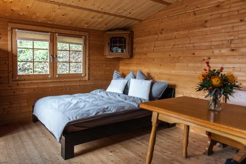 a bedroom in a log cabin with a bed and a table at Hüttenzauber im Naturpark Altmühltal in Greding