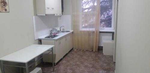 a kitchen with white cabinets and a sink and a window at комфорт in Marneuli