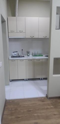 a kitchen with white cabinets and a sink at комфорт in Marneuli