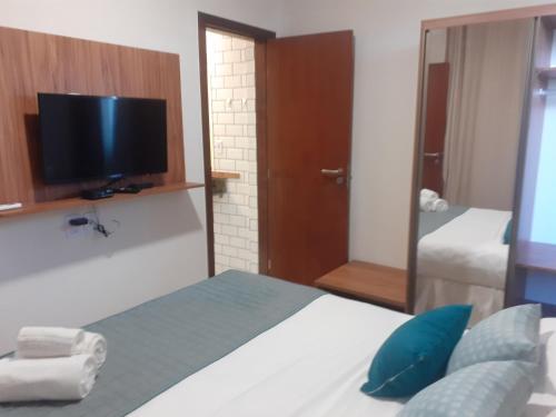 a bedroom with a bed and a tv and a mirror at Tree Bies Resort - Oficial in Subaúma