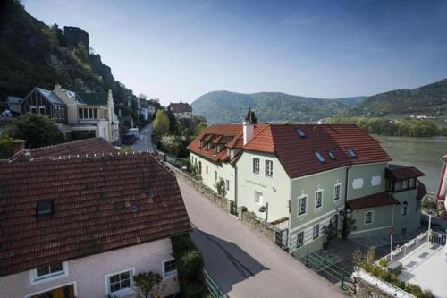a view of a town with houses and a river at Winzerhof - Gästehaus Stöger in Dürnstein