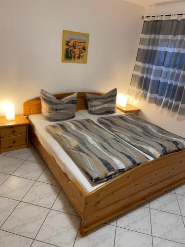 a bedroom with a wooden bed with pillows on it at Ferienwohnung Winkler in Lahnstein bei Koblenz am Rhein in Lahnstein