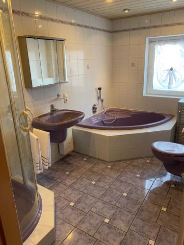 a bathroom with a tub and a sink and a toilet at Ferienwohnung Winkler in Lahnstein bei Koblenz am Rhein in Lahnstein