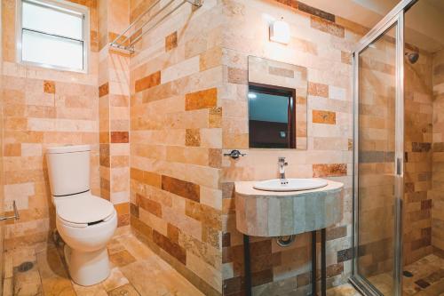 Hotel Granda Inn في توكستلا غوتيريز: حمام مع مرحاض ومغسلة