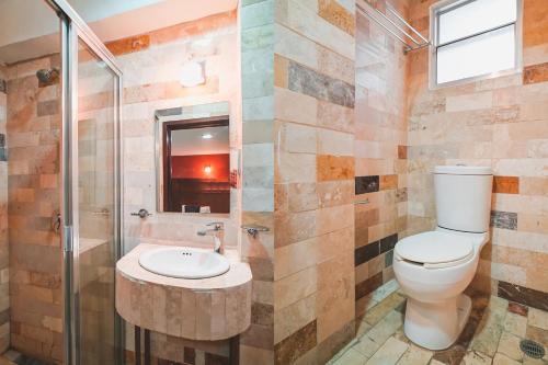 a bathroom with a toilet and a shower and a sink at Hotel Granda Inn in Tuxtla Gutiérrez