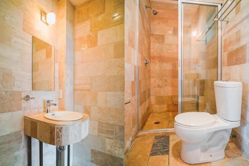 a bathroom with a toilet and a shower and a sink at Hotel Granda Inn in Tuxtla Gutiérrez