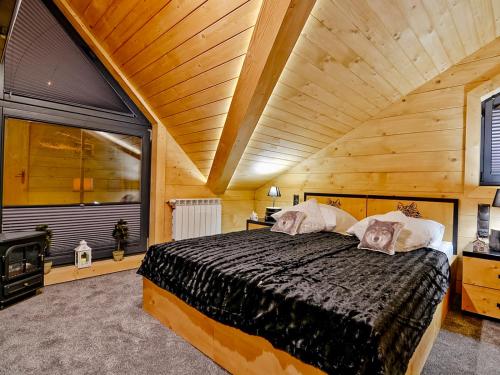 1 dormitorio con 1 cama grande y techo de madera en Domki Vika Home i Wataha Home - w samym centrum zakopanego - 10min pieszo do Krupówek, en Zakopane