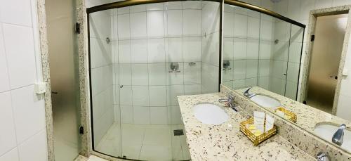 a bathroom with two sinks and a shower at Hotel Golden Park Sorocaba & Convenções by Nacional Inn in Sorocaba