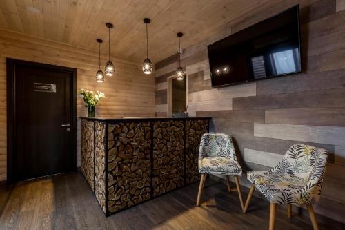 a lobby with a bar with two chairs and a television at SPA Hotel Galera in Kyiv