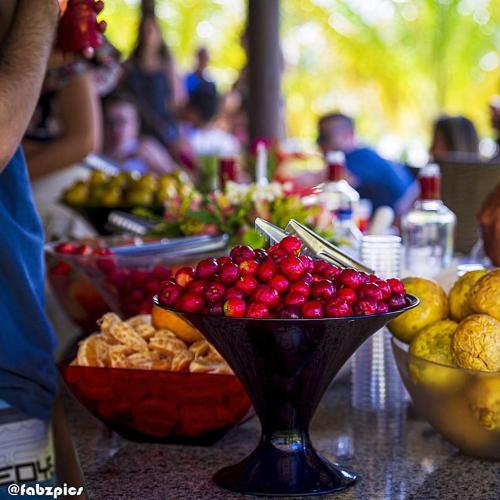 a bowl of cherries on a table with other fruit at Tree Bies Resort - Oficial in Subaúma