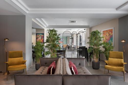 a living room with a couch and two chairs at Hotel Argento in St. Julianʼs