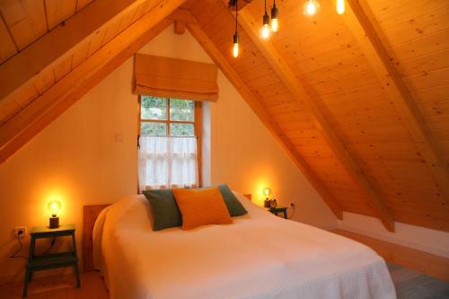 a bedroom with a white bed in a attic at Döme's Point in Leányfalu